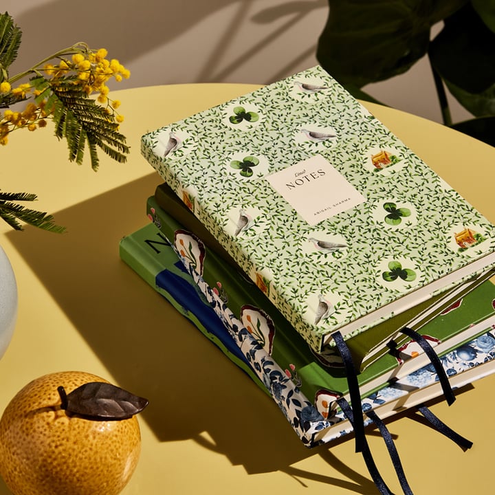 A green notebook by Papier on a table